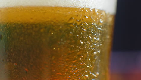 Beer-closeup.-Pint-of-cold-Craft-beer-isolated-on-matte-black-background-rotation-360-degrees.-Glass-of-beer-with-water-drops.